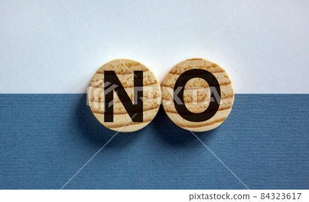Wood circles with word 'no' on paper white and blue background, copy space. Business concept. Wood circles with word 'no' on paper white and blue background, copy space. Business concept. 84323617