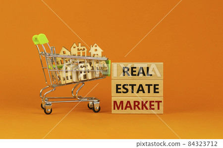 Real estate market symbol. Wooden blocks, words 'Real estate market' on beautiful orange background. Shopping cart with miniature wooden houses. Business, Real estate market concept. Copy space. Real estate market symbol. Wooden blocks, words 'Real estate market' on beautiful orange background. Shopping cart with miniature wooden houses. Business, Real estate market concept. Copy space. 84323712