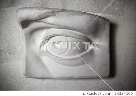 Sculpture of eye on the grey wall 84324109
