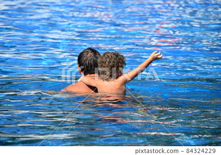 Child and adult swim in the sea. Child and adult swim in the sea. 84324229