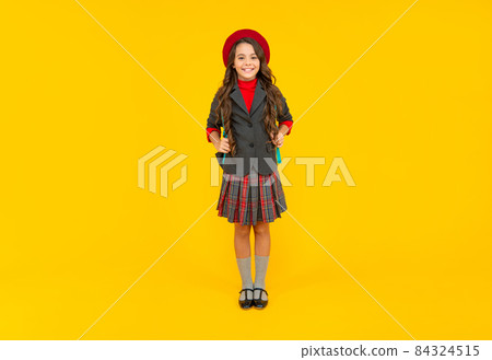 smiling child in school uniform and beret full length on yellow background, schoolgirl smiling child in school uniform and beret full length on yellow background, schoolgirl 84324515