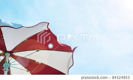 Umbrella beach. Red summer beach parasol on blue sea background. Sun sunshade for vacation travel. Outdoor relax holiday at ocean with copy space. 84324953