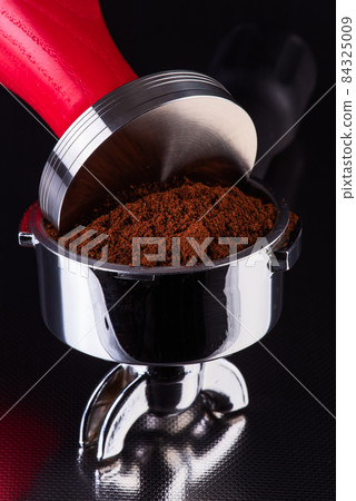 Barista accessories, portafilter with fresh ground coffee and tamper on shiny table bar close-up view Barista accessories, portafilter with fresh ground coffee and tamper on shiny table bar close-up view 84325009