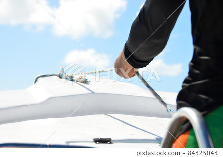 Closeup on man holding rope on the yacht, body part. Closeup on man holding rope on the yacht, body part. 84325043