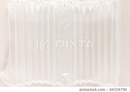 Air column cushioning sleeve wrap for bottles. Bubble foil for wrapping. Abstract background. Closeup, pollution and fragile package delivering concept Air column cushioning sleeve wrap for bottles. Bubble foil for wrapping. Abstract background. Closeup, pollution and fragile package delivering concept 84326790