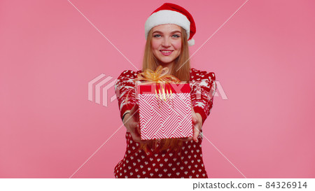 Joyful girl in red Christmas sweater with deers presenting Christmas gift box, shopping holiday sale Joyful girl in red Christmas sweater with deers presenting Christmas gift box, shopping holiday sale 84326914
