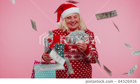 Senior grandmother woman spending money on Christmas holiday holding sale gift boxes, shopping bags Senior grandmother woman spending money on Christmas holiday holding sale gift boxes, shopping bags 84326916