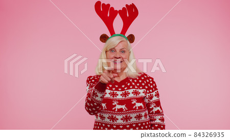Senior Christmas grandmother woman smiling excitedly pointing to camera beauty choosing lucky winner Senior Christmas grandmother woman smiling excitedly pointing to camera beauty choosing lucky winner 84326935