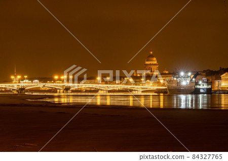 The panoramic footage of the winter night city Saint-Petersburg with picturesque reflection on water, big ship moored near Blagoveshchensky bridge or lieutenant Schmidt, Isaac cathedral on background 84327765