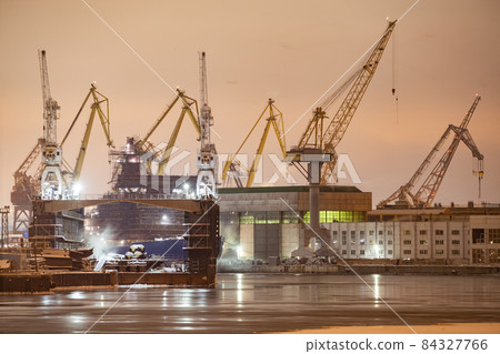 The construction of nuclear icebreakers at night, cranes of of the Baltic shipyard in a frosty winter day, steam over the Neva river, smooth surface of the river, fog The construction of nuclear icebreakers at night, cranes of of the Baltic shipyard in a frosty winter day, steam over the Neva river, smooth surface of the river, fog 84327766