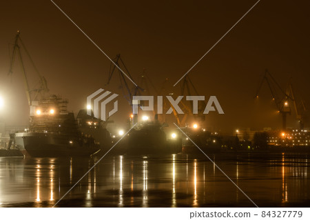 The construction of nuclear icebreakers at night, cranes of of the Baltic shipyard in a frosty winter day, steam over the Neva river, smooth surface of the river, fog The construction of nuclear icebreakers at night, cranes of of the Baltic shipyard in a frosty winter day, steam over the Neva river, smooth surface of the river, fog 84327779
