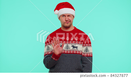 Confused man in sweater Santa Christmas hat pointing fingers himself ask say who why me no thanks 84327877