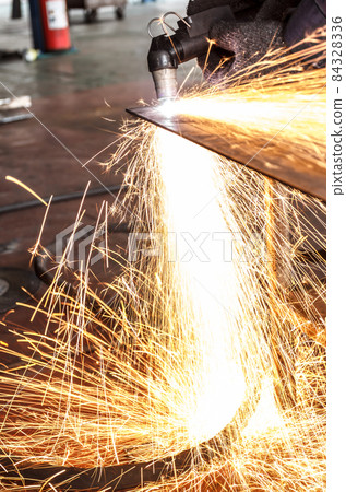 Sparks while cutting steel in the factory Sparks while cutting steel in the factory 84328336