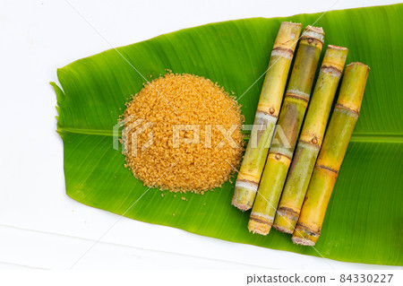 Sugar cane with brown sugar on banana leaf Sugar cane with brown sugar on banana leaf 84330227