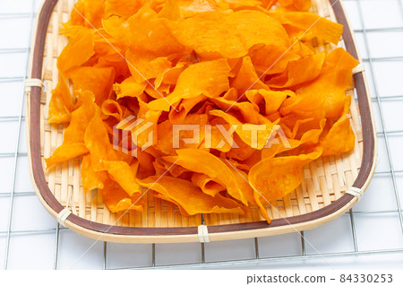 Sweet potato chips in bamboo basket on white background. Sweet potato chips in bamboo basket on white background. 84330253