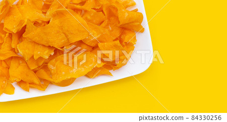 Sweet potato chips in white plate on yellow background. 84330256