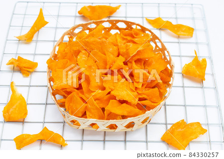 Sweet potato chips in bamboo basket on white background. 84330257