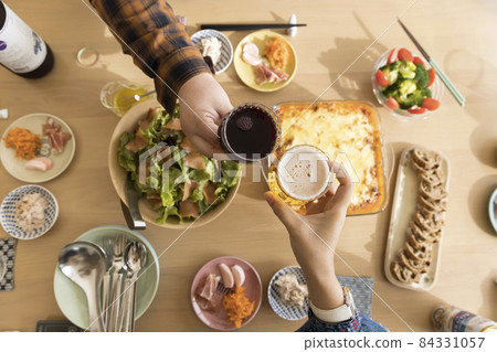 Image of girls-only gathering: Women who have a toast with the dishes lined up on the table 84331057