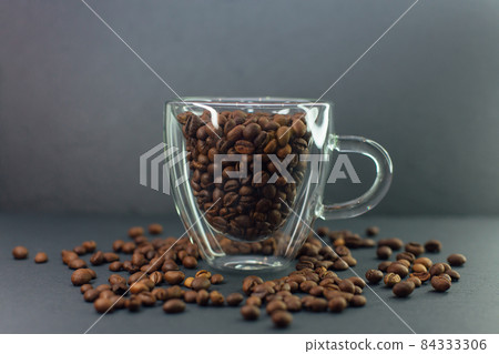 Transparent coffee cup full of coffee beans. 84333306
