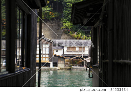 Houses on the opposite bank seen through the gaps in the boathouse Houses on the opposite bank seen through the gaps in the boathouse 84333584