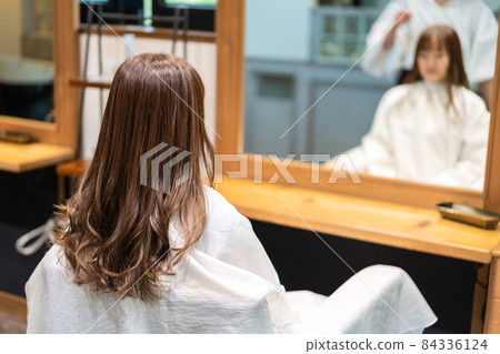 Hairdresser using a hair iron Hairdresser using a hair iron 84336124