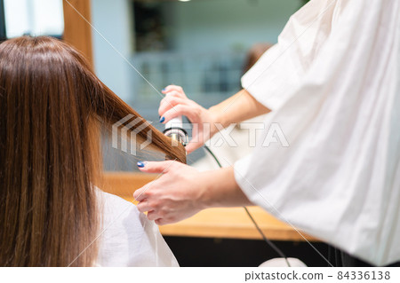 Hairdresser using a hair iron Hairdresser using a hair iron 84336138