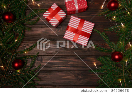 gift boxes and fir branches on a wooden background. 84336678