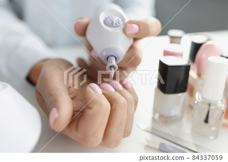 Apparatus for manicure in woman hand closeup 84337059