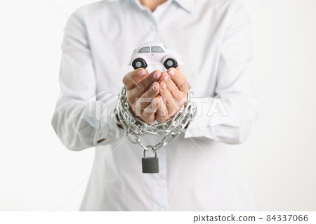 Toy car in female hands wrapped in chain 84337066