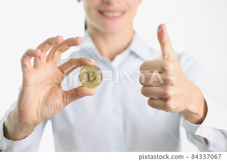 Gold bitcoin and thumbs up in female hand Gold bitcoin and thumbs up in female hand 84337067