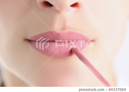 Female lips with pink lipstick and brush closeup Female lips with pink lipstick and brush closeup 84337069