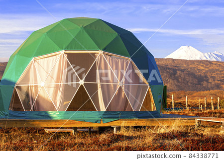Green geo-dome tent on Kamchatka peninsula. Cozy, camping, glamping, holiday, vacation lifestyle concept. Outdoors cabin, scenic background Green geo-dome tent on Kamchatka peninsula. Cozy, camping, glamping, holiday, vacation lifestyle concept. Outdoors cabin, scenic background 84338771