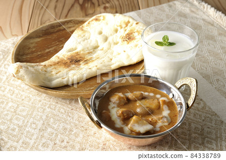 Massaman curry, naan and lassie with lots of ingredients such as chicken and peanuts 84338789