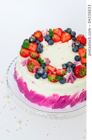 Delicate cake decorated with fresh berries strawberries blueberries white plain background. Festive dessert with berries Delicate cake decorated with fresh berries strawberries blueberries white plain background. Festive dessert with berries 84338833