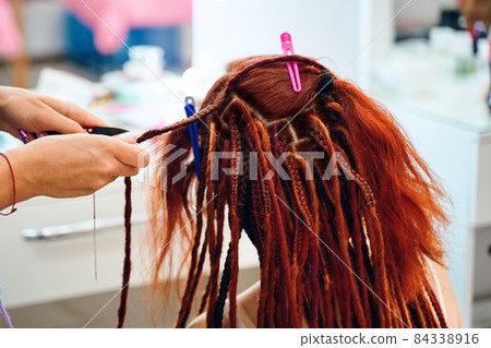 Braiding process african plaits with colored - Stock Photo