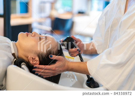 Cosmetologist shampooing customers 84338972