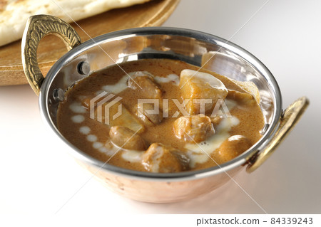 Massaman curry and naan with lots of ingredients such as chicken and peanuts taken on a white background 84339243