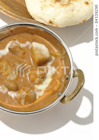 A bird's-eye view of Massaman curry and naan containing many ingredients such as chicken and peanuts on a white background A bird's-eye view of Massaman curry and naan containing many ingredients such as chicken and peanuts on a white background 84339290
