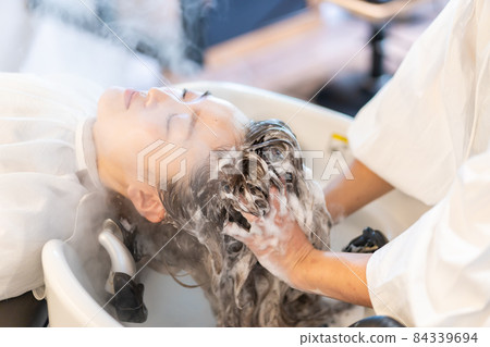 Female receiving steam treatment at a hair dressing Female receiving steam treatment at a hair dressing 84339694