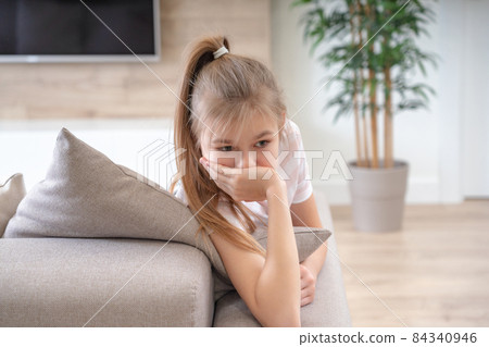 Preteenage sad girl sitting on a couch with copy space 84340946
