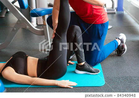 personal trainer man working with young woman in modern gym 84340948