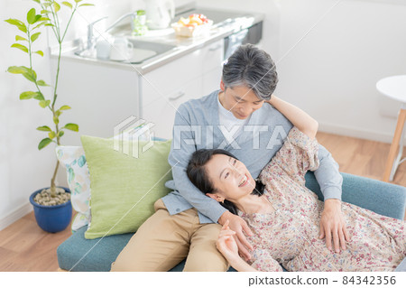 Middle-aged man wearing a knee pillow and a woman lying down 84342356