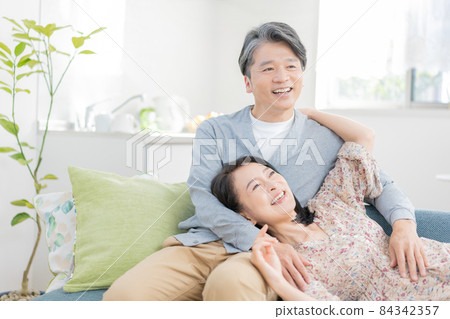 Middle-aged man wearing a knee pillow and a woman lying down 84342357