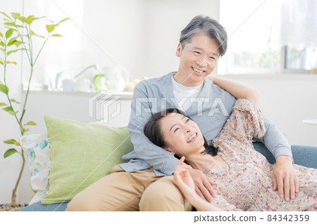 Middle-aged man wearing a knee pillow and a woman lying down Middle-aged man wearing a knee pillow and a woman lying down 84342359