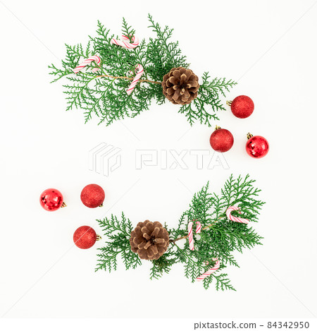 Merry Christmas frame composition with green branches and red balls on white background. Flat lay 84342950