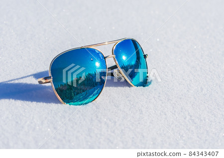 Sunglasses with blue lenses reflecting the forest Sunglasses with blue lenses reflecting the forest 84343407