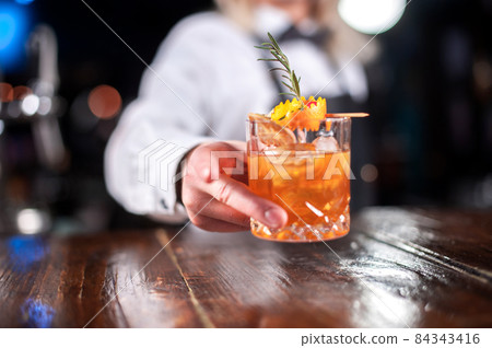 Girl barman concocts a cocktail at the public house Girl barman concocts a cocktail at the public house 84343416