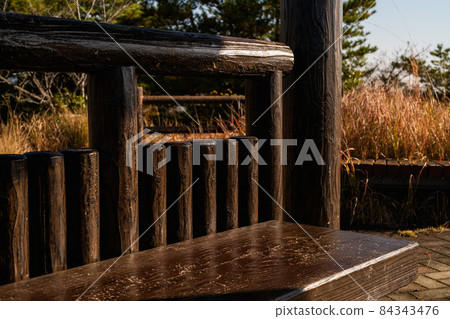 Park bench in the setting sun, chair made of brown stone, lonely image of autumn 84343476