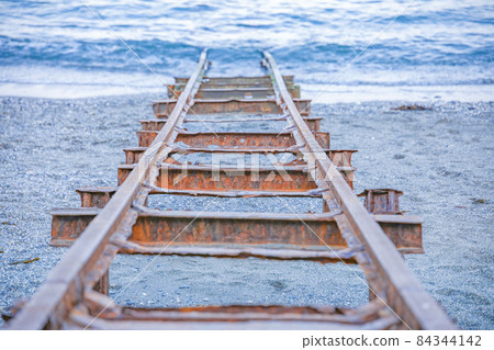 Railroad tracks leading to the sea 84344142