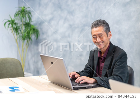 Elderly man using a personal computer 84344155